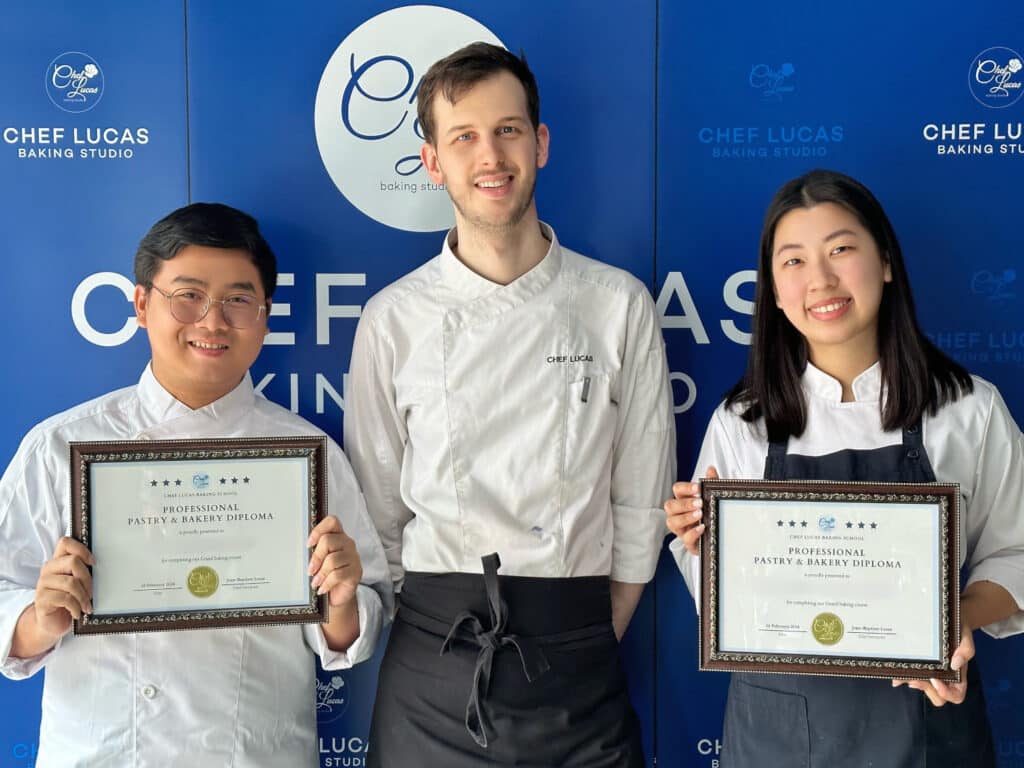 Chef Lucas and proud students hold their certificate on graduation day, celebrating the successful completion of the 5-week intensive baking program.